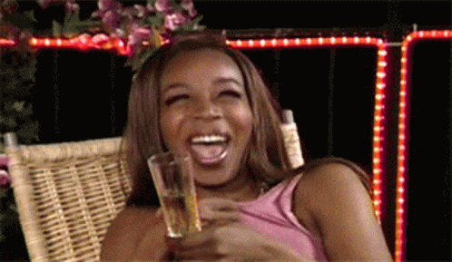 Black woman laughing with glass of wine GIF Tiffany Pollard